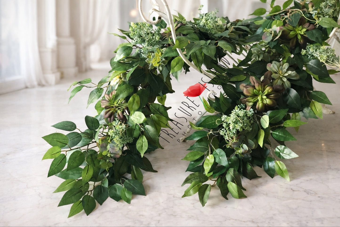 Lush green foliage garland arranged on white decorative bench – elegant backdrop for newborn and maternity photography sessions