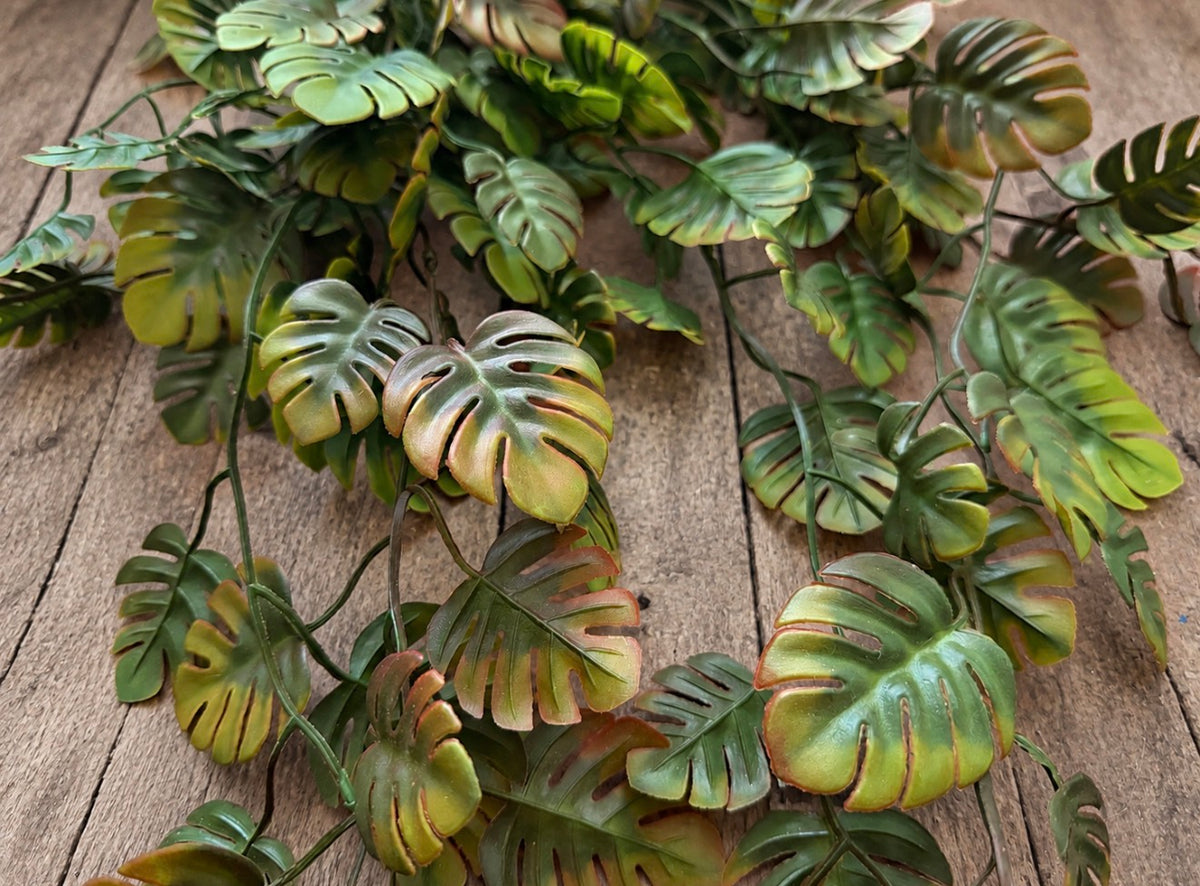 Close-up of layered green mini monstera leaves and botanical details on a photography garland