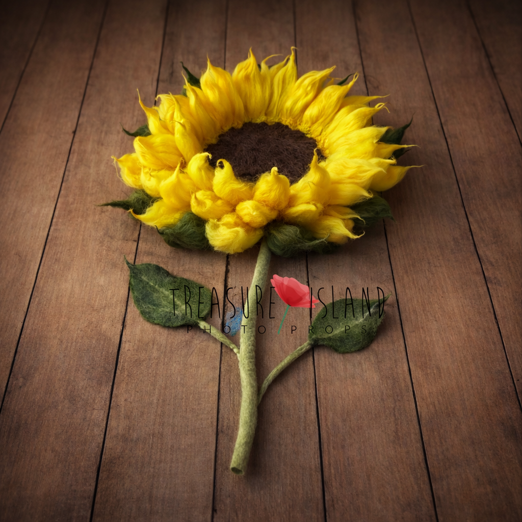 Luxury handmade sunflower newborn photography blanket with long felted stem and leaves, crafted from soft merino wool and styled on vintage wooden floor. Fine art floral baby photo prop by Treasure Island Photo Props.
