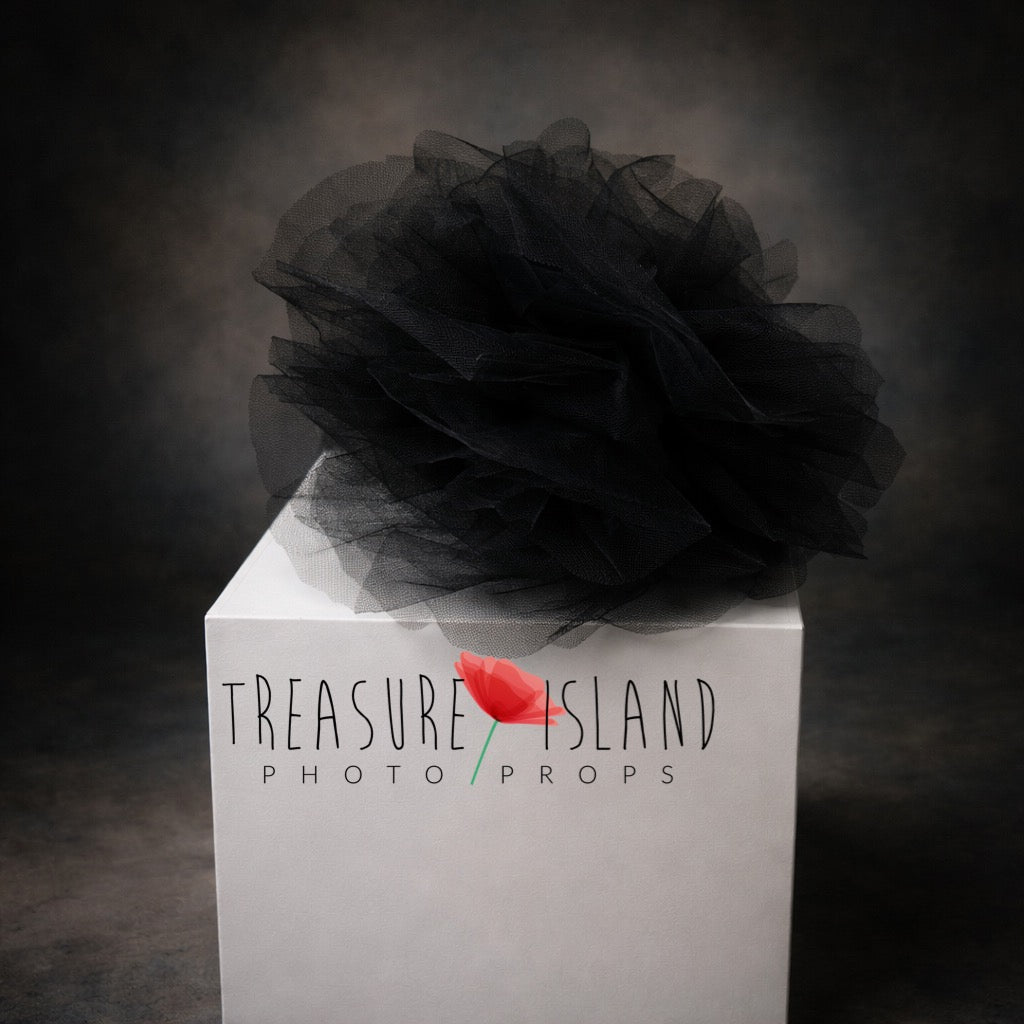 Black tulle newborn photography prop on white cube with dark fine art background, soft layered texture, luxury styling
