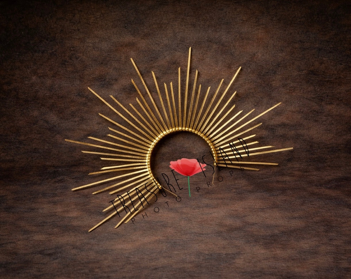 Golden sunburst newborn photography headpiece with delicate rays, styled on dark neutral fine art textured background
