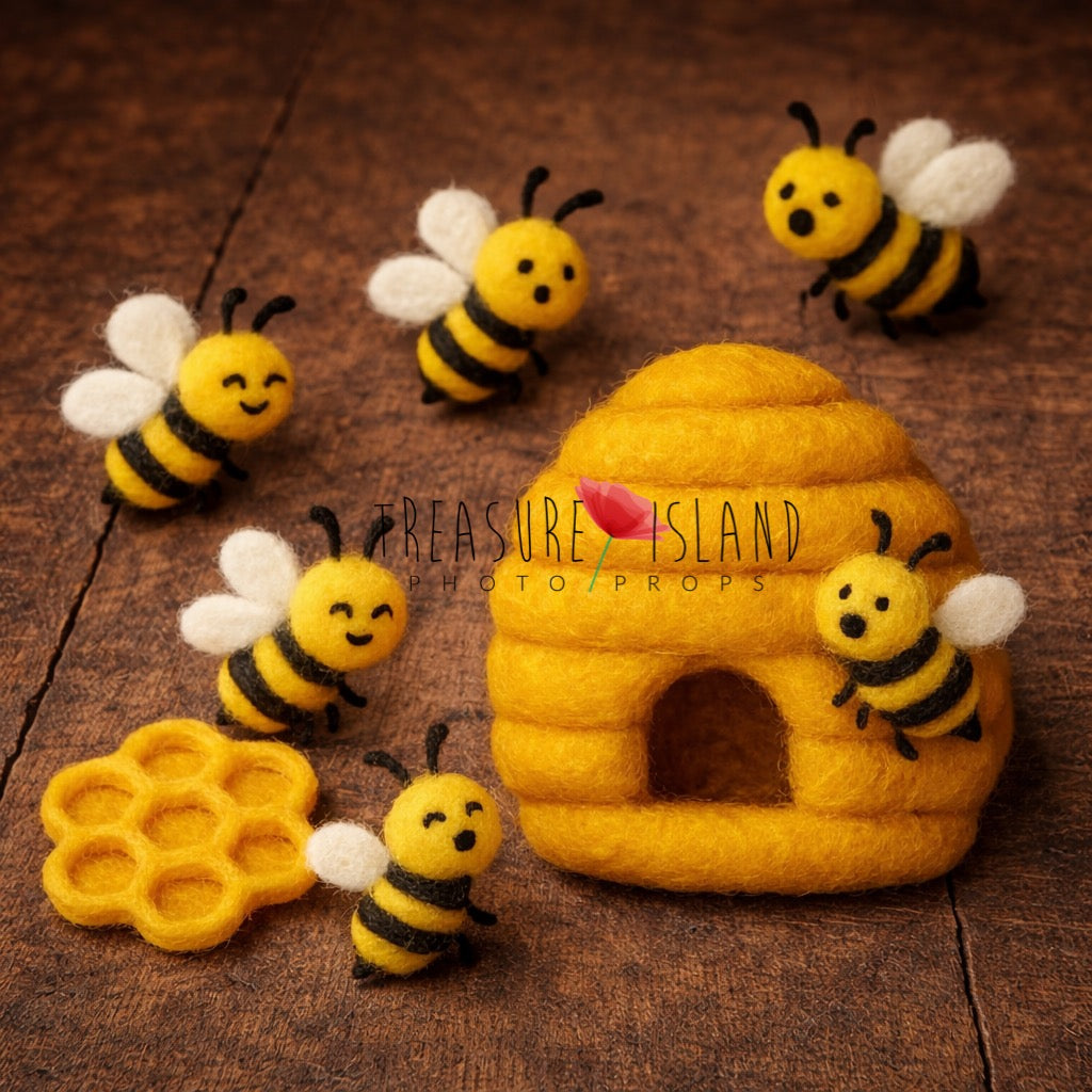 Handmade felt bee set with yellow beehive, honeycomb and small wool bees arranged on a rustic dark wooden background, newborn photography prop styling