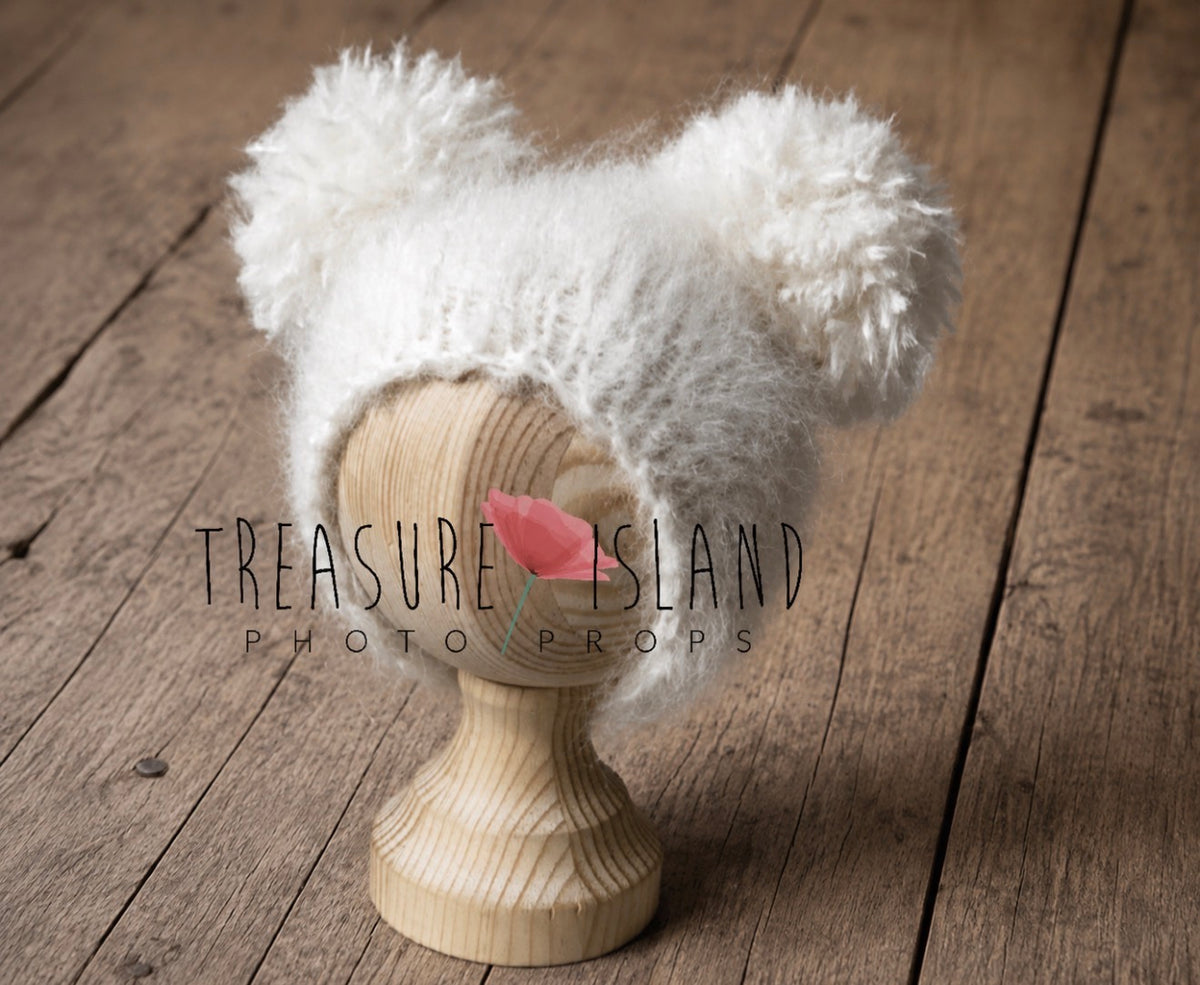 Natural white fluffy knitted baby hat with two oversized pom poms for newborn photography