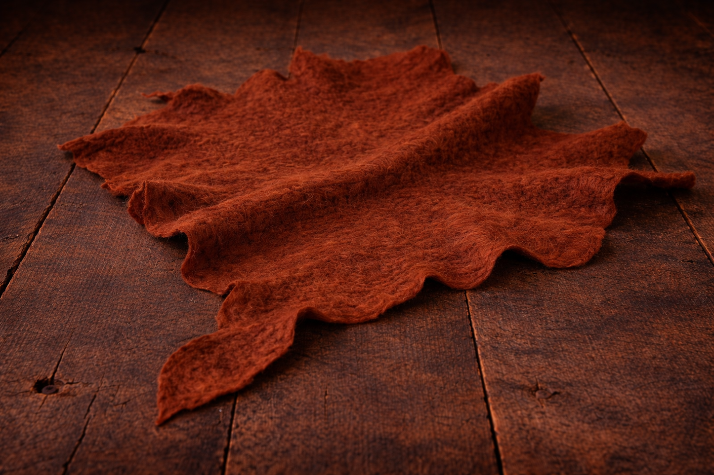 Rust hand-felted irregular wool blanket with organic edges