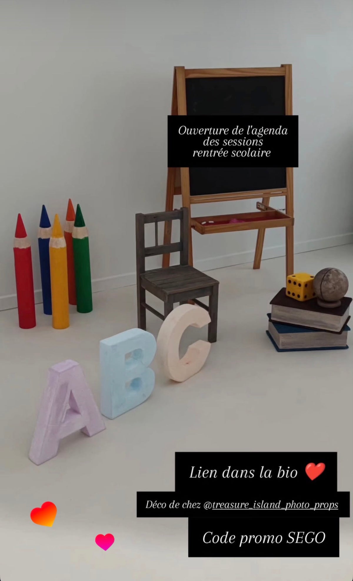 Client photography studio setup featuring oversized styrofoam ABC letters, giant colorful crayons, decorative books, dice and globe for school portraits.