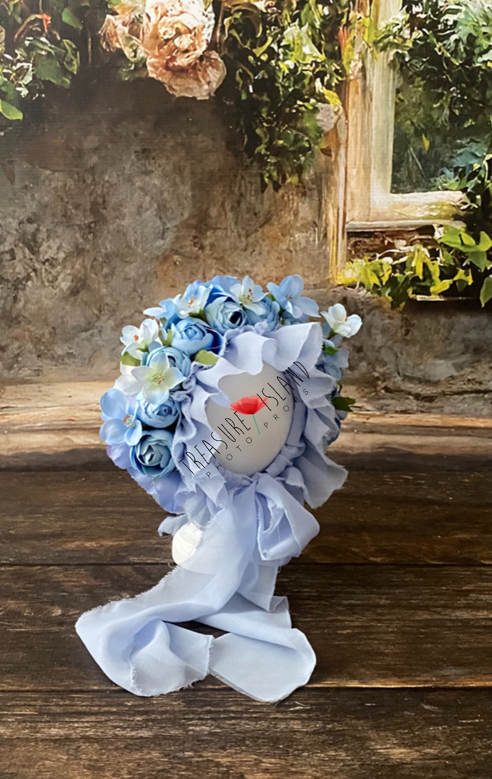 Side view of blue flower bonnet showing its dimensional floral arrangement and flowing ties