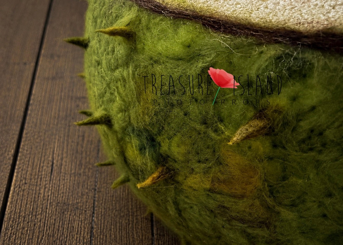 Detailed green wool felting and handmade spikes on artistic chestnut photography prop