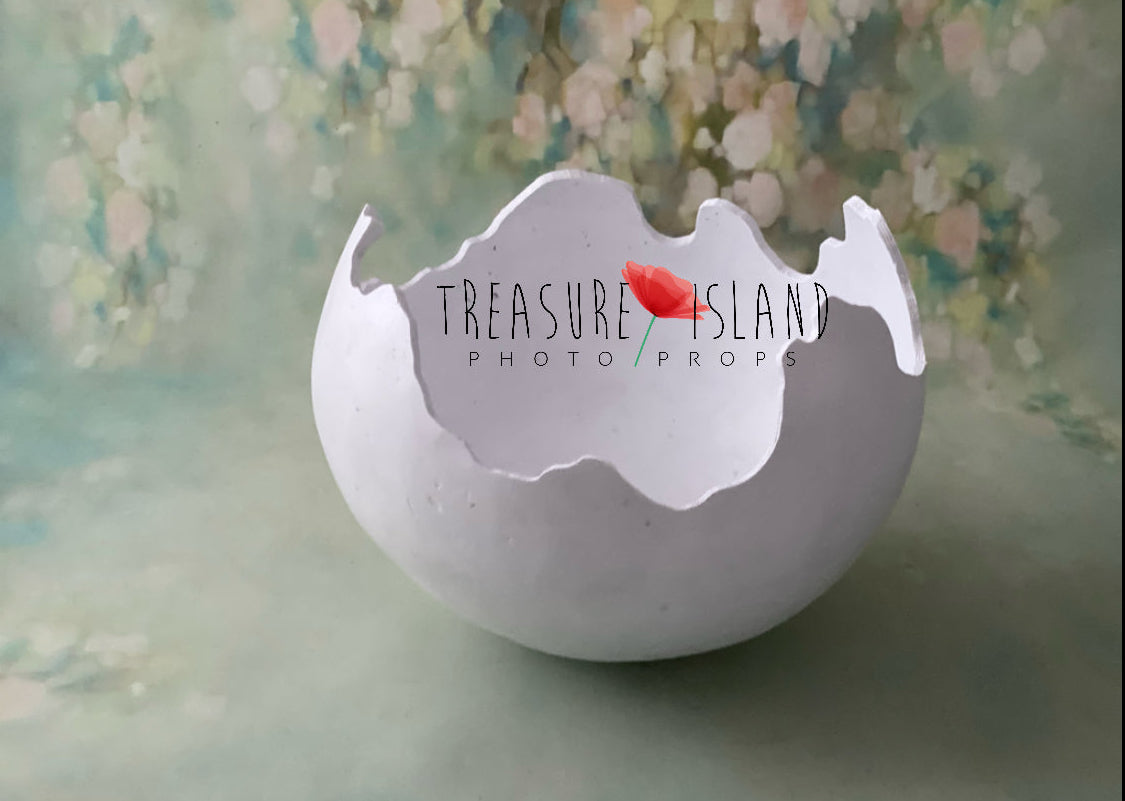 Cracked plaster dinosaur egg photography prop with organic hand-shaped shell opening