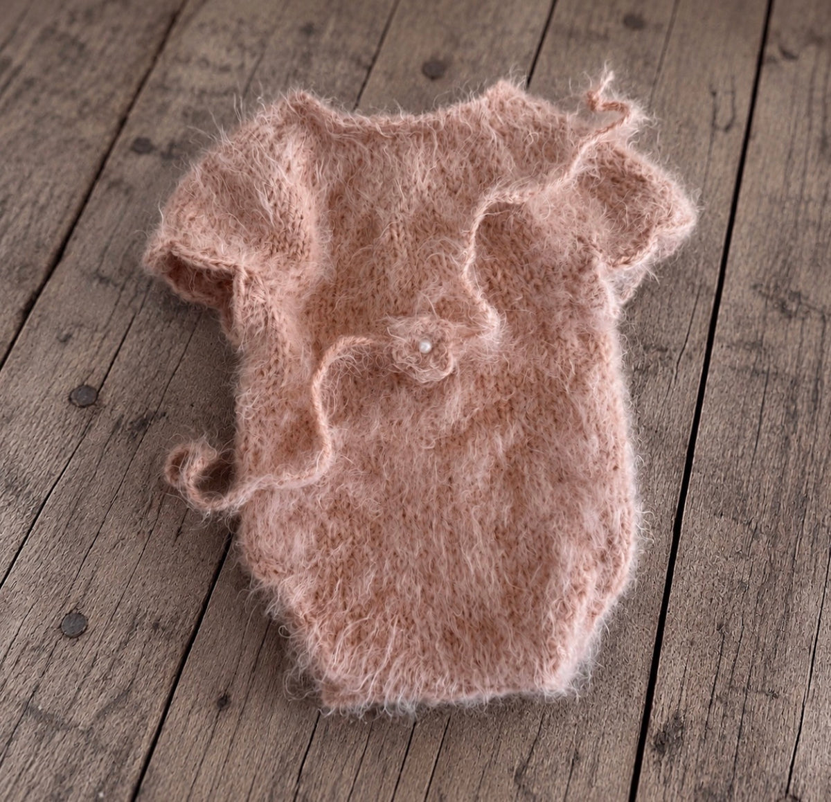 Soft dusty pink fluffy knitted bodysuit with short sleeves and matching flower headband featuring a small pearl-like centre.