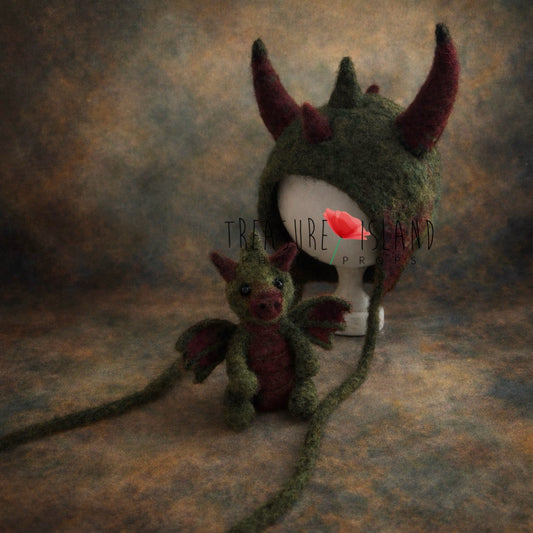 Forest green felted dragon bonnet and matching dragon toy set for newborn fantasy photography
