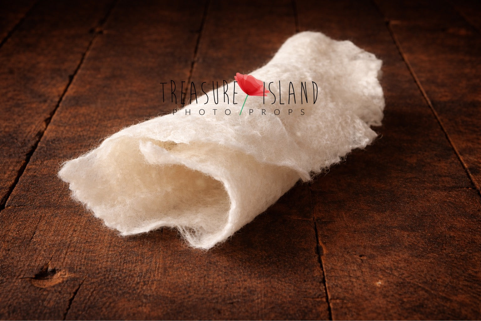 Rolled white hand-felted wool photography blanket showing soft felt texture