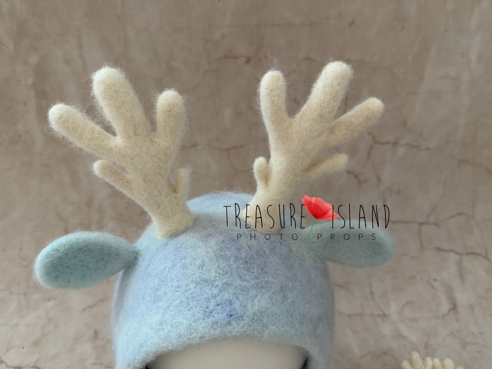 Close-up of handmade wool antlers and ears on an icy blue felted reindeer bonnet