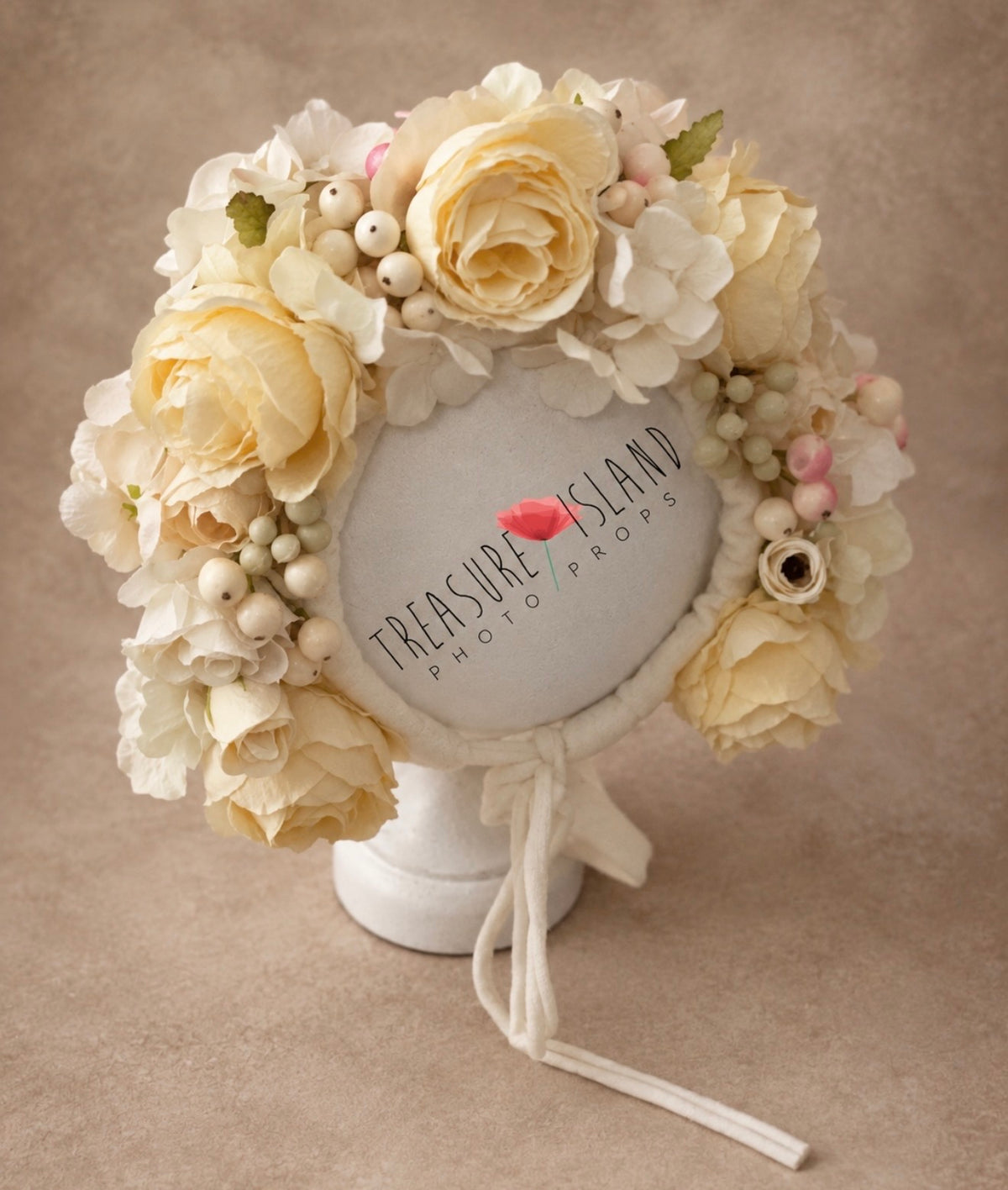 Front view of handmade cream floral photography bonnet decorated with layered artificial flowers