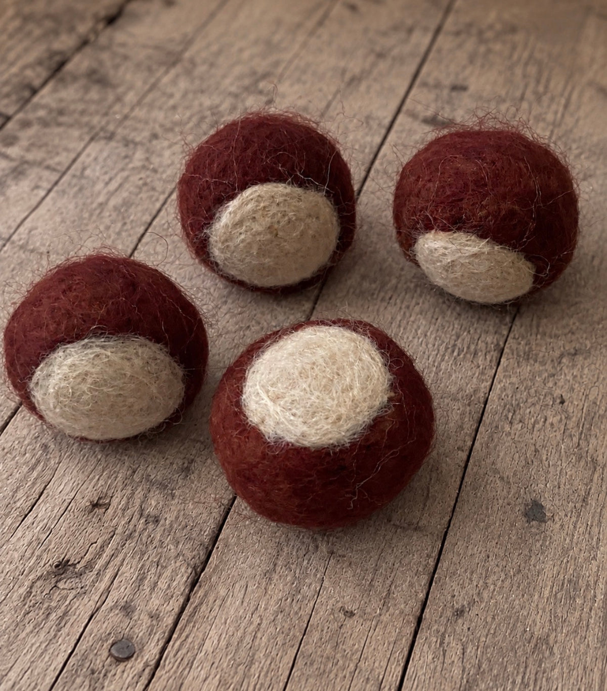 Four handmade wool felted chestnuts in chestnut brown and natural cream