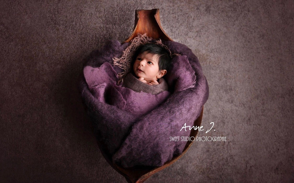 Heather and plum hand-felted irregular wool blanket styled around a newborn in a photography bowl