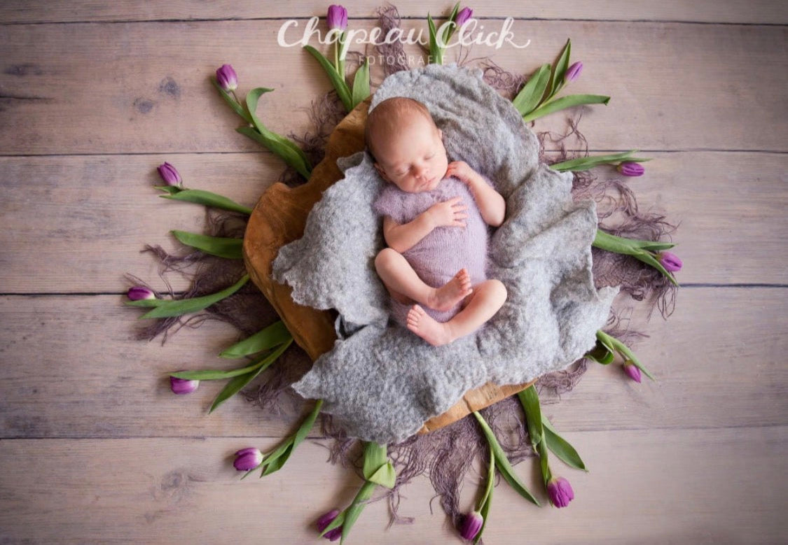 Light grey and grey melange hand-felted irregular wool blanket arranged like soft flower petals for newborn photography