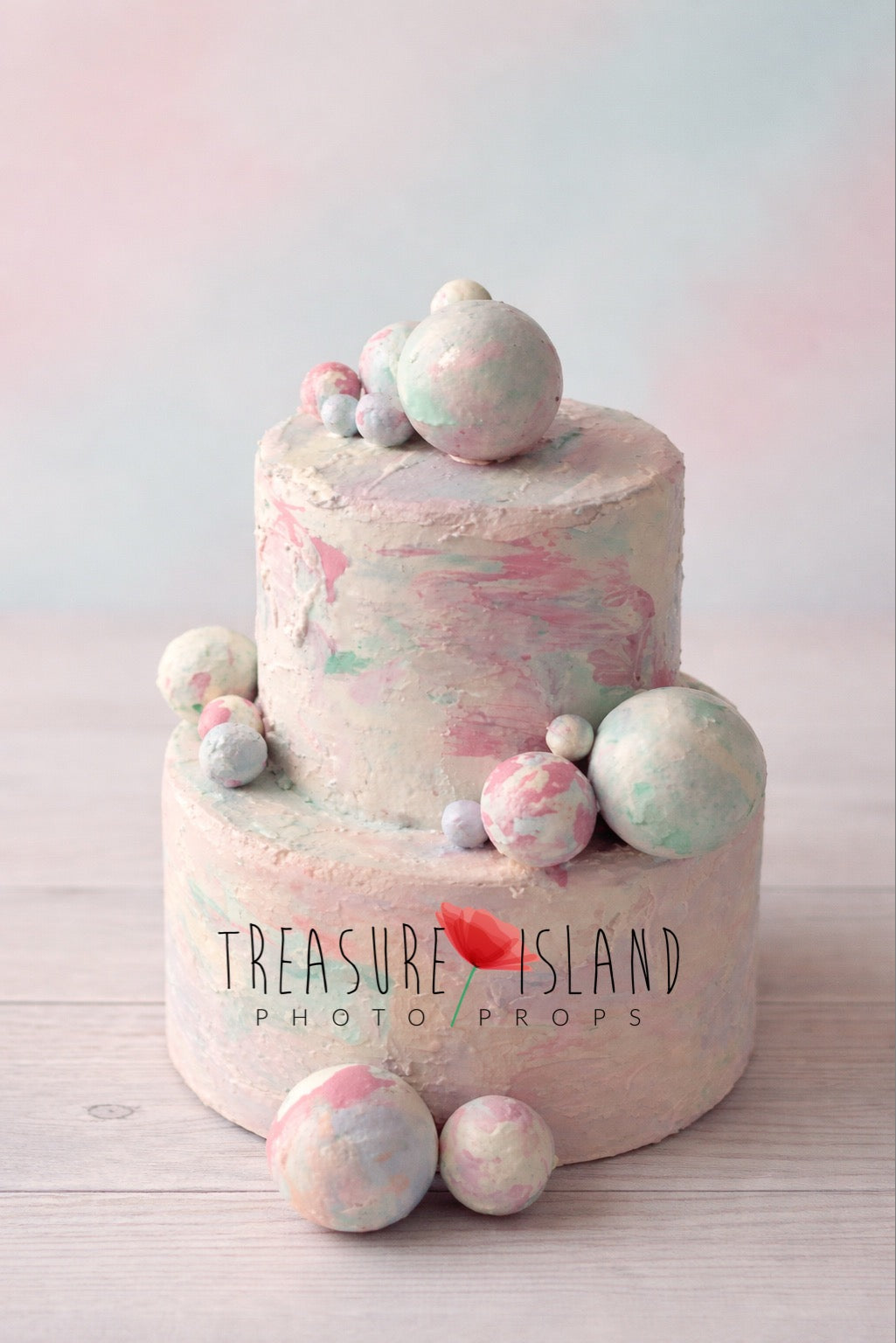 Pastel two-tier styrofoam cake photography prop with textured finish and decorative spheres