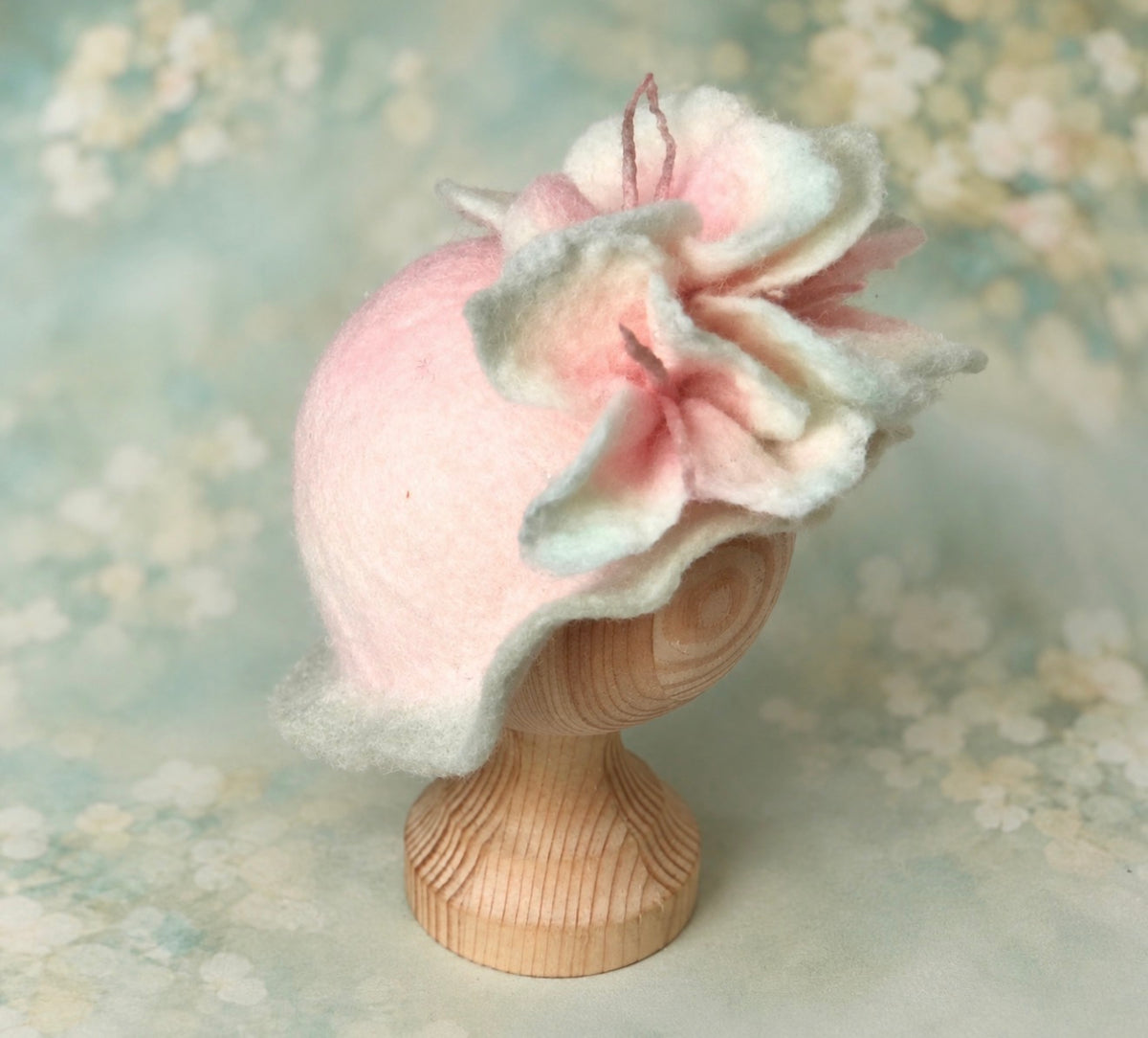 Side view of handmade pink and pale sage felted flower petal hat with delicate wool stamens for newborn photography