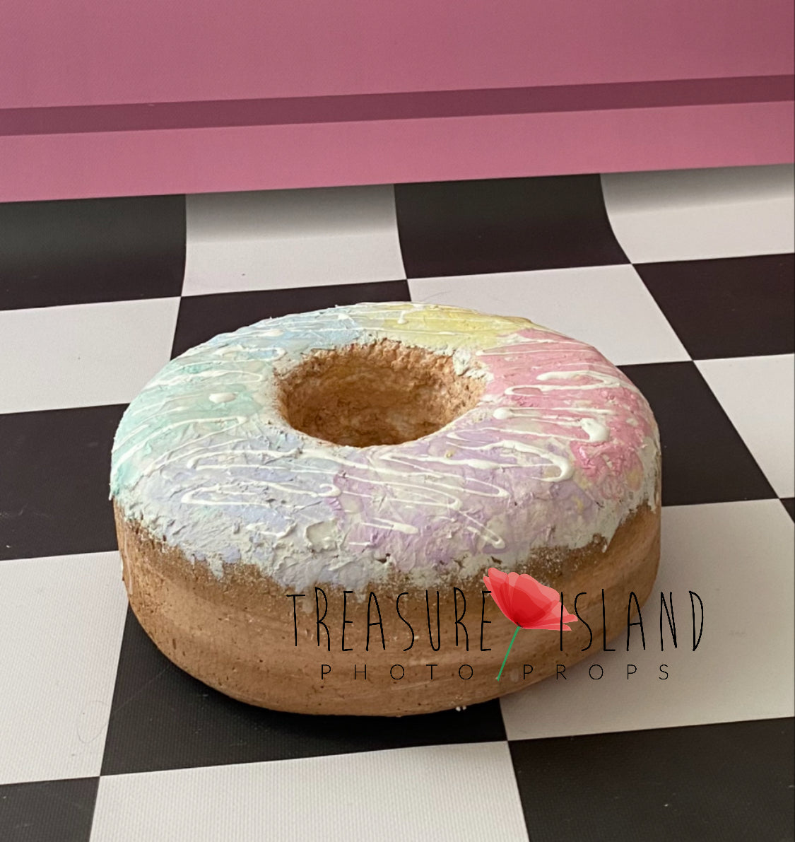 Handmade styrofoam donut photography prop with pastel rainbow glaze and white drizzle