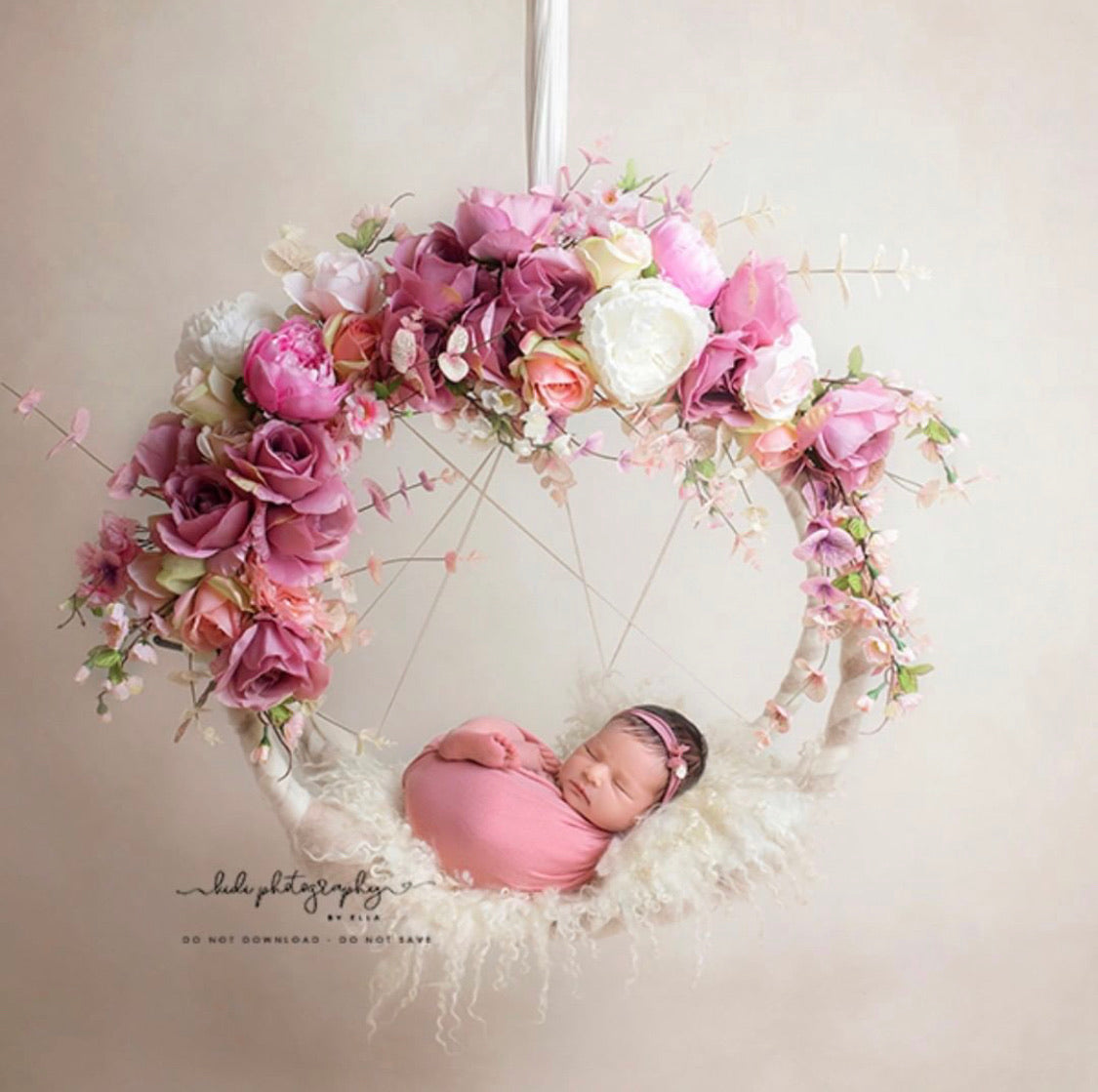 Hanging floral dream catcher used as a newborn photography prop with pink and ivory flowers