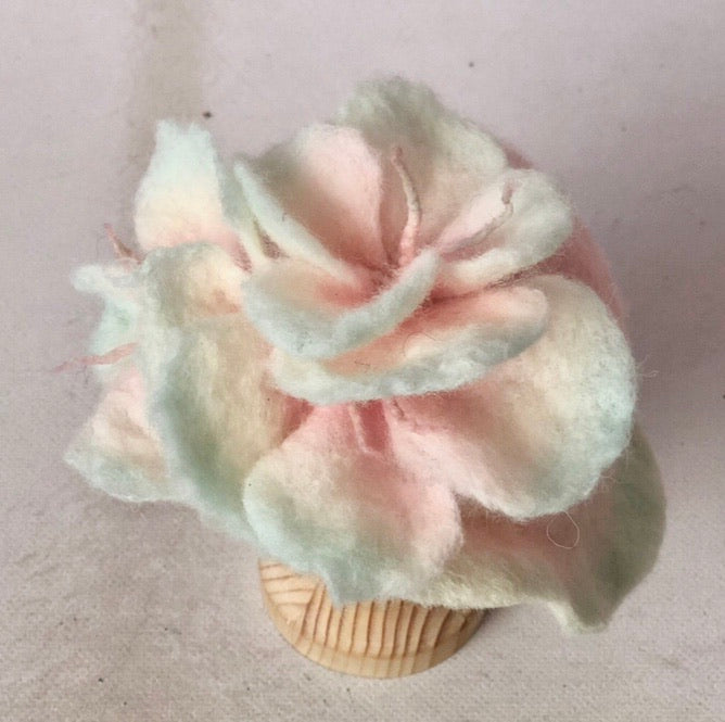 Original top view of hand-felted pink and green floral photography hat showing individual wool petals and fine stamens