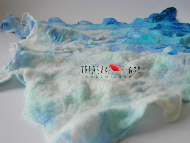 Close view of seafoam and pale aqua felted waves on the handmade Ocean Wave blanket